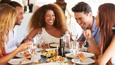 mensen zitten lekker aan tafel te genieten
