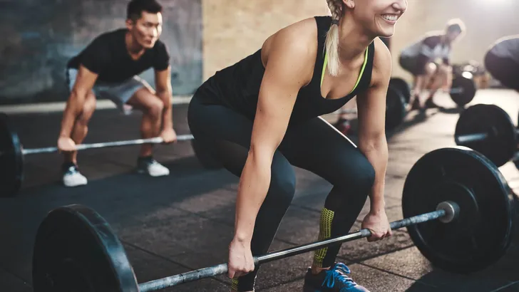 Woman performing dead lift barbell exercise