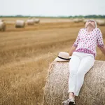 Happy attractive senior woman in a field in summer