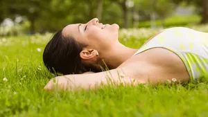 Peaceful fit brunette lying on the grass