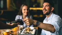 man paying bill at fancy restaurant