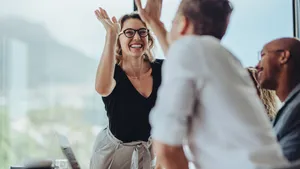 Businesswoman giving a high five to a colleague in meeting