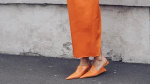 Streetstyle-foto van vrouw met oranje rok en matchende oranje pumps. – Oranje must-haves voor Koningsdag.