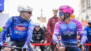 Jasper Philipsen en Dylan Groenewegen kijken elkaar lachend aan voor de start van een Vlaamse wedstrijd.
