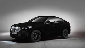 BMW X6 in Vantablack, de zwartste autokleur ter wereld, in driekwart vooraanzicht tegen een grijze studioachtergrond