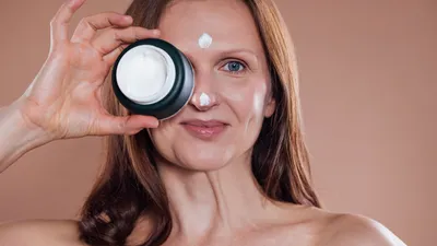 Vrouw houdt crème voor gezicht