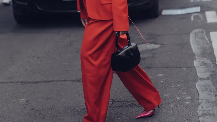 De Weekendtips van Beau Monde, week 12 2025. – Streetstyle-foto van vrouw in rood oversized broekpak.