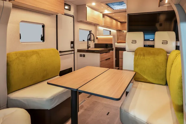 Woonruimte en keuken van een Bürstner Signature-camper zonder zichtbare hoge koelkast
