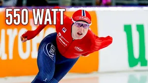 Schaatser Sander Eitrem in diepe, aerodynamische houding tijdens zijn wereldrecordrace op de 5 kilometer, met een grafische weergave van de 550 watt vermogen die hij leverde.