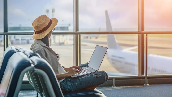 passenger or traveler tourist looking at the aircraft in park lane terminal, worry of the flight schedule in late or delay, sitting upset in the transit hall of the airport waiting for aircraft