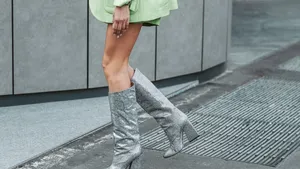 Street style, woman wearing neon green cardigan and shorts, matching neon green blazer jacket and heels knees boots.