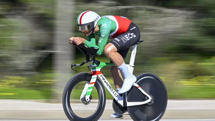 Filippo Ganna in zijn Italiaanse kampioenstrui op zijn tijdritfiets in volle inspanning bezig aan een tijdrit.