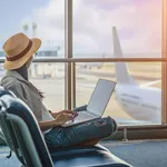 passenger or traveler tourist looking at the aircraft in park lane terminal, worry of the flight schedule in late or delay, sitting upset in the transit hall of the airport waiting for aircraft