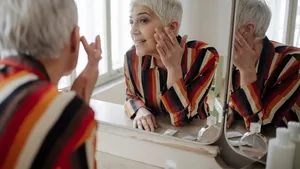 Woman Applying Cosmetic Cream on her Face