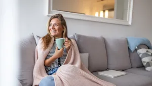 Vrouw dit op de bank met kleedje en kopje thee