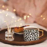 Cup of coffee with home perfume in bed