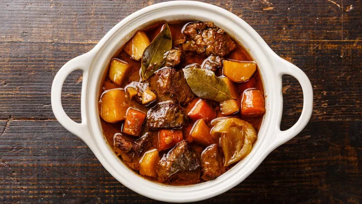 Beef meat stewed with potatoes, carrots and spices in ceramic po