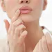 Perfecte lippenbalsem – Vrouw bij spiegel met lippenbalsem.