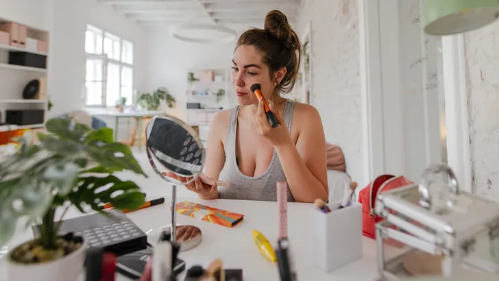 Young woman applying make-up