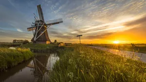 Wooden windmill canal cycling track at sunset