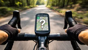 Fietscomputer op het stuur met kaart op het scherm en een groot vraagteken, gefotografeerd vanuit het perspectief van de fietser op een bosweg.