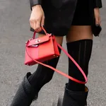 Paris, France - October, 1, 2022: woman wearing black leather Kelly handbag from Hermes, street style outfit.