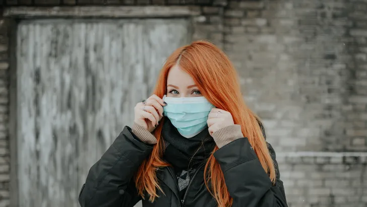 Een jongedame met een mondkapje.
