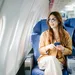 Foto van vrouw in vliegtuig. – Travel essentials voor comfortabele vliegreis