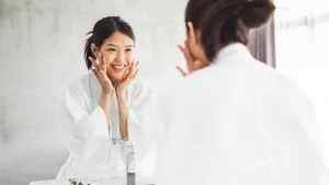 Asian woman cleaning face front of mirror, skin care and cosmetic removal concept