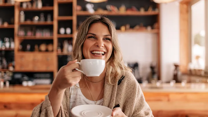 vrouw drinkt koffie en heeft goed humeur