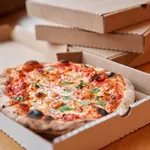 Pizza delivery concept. Baked products in a cardboard box against a wooden background. Baked tasty margherita pizza in Traditional wood oven in Neapolitan restaurant, Italy.