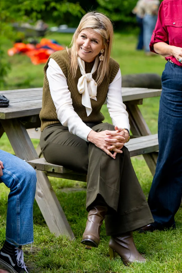 Koningin Máxima op een bankje in mooie groene outfit.