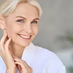 Portrait of smiling mid age woman looking at camera. Skin care concept.