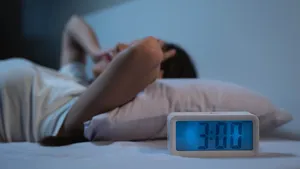 woman have insomnia on the bed selective focus on alarm clock at