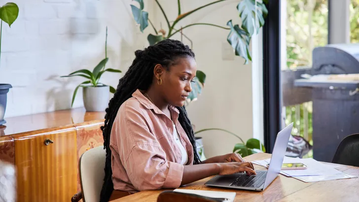 Young woman working remotely from home using a laptop