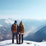 Couple with backpacks hiking in snowy mountains enjoying mountain view in winter.