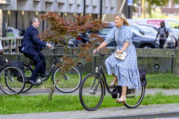 Koningin Máxima draagt een hak van topdesigner Ferragamo en een lichte crossbodytas van Marina Raphael.