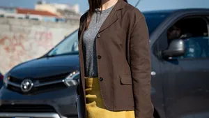 Vrouw in stijlvolle outfit met botergele accenten.