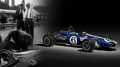Blauwe AAR Eagle Formule 1-auto met startnummer 6 naast Enzo Ferrari die de auto bekijkt.