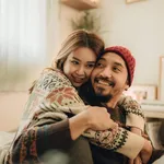 Happy young couple relaxing talking laughing drinking coffee tea