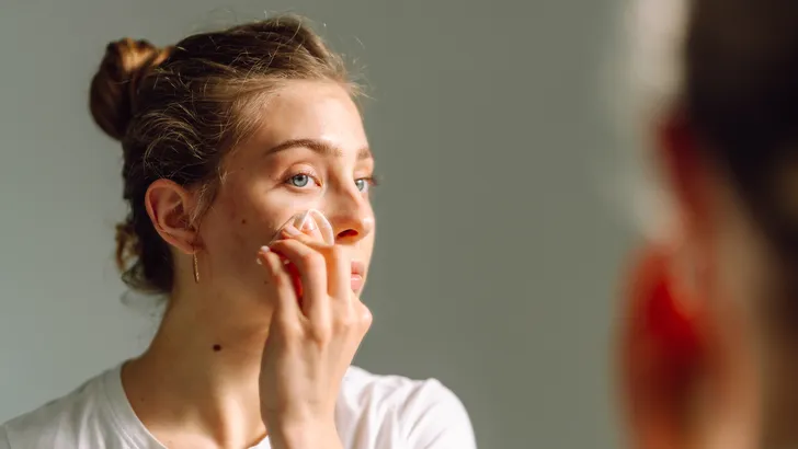 Vrouw reinigt gezicht met toner pads.