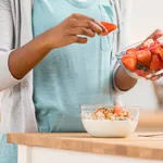 Unrecognizable woman prepares parfait at kitchen counter