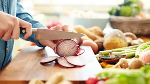Midsection image of woman cutting onion in kitchen