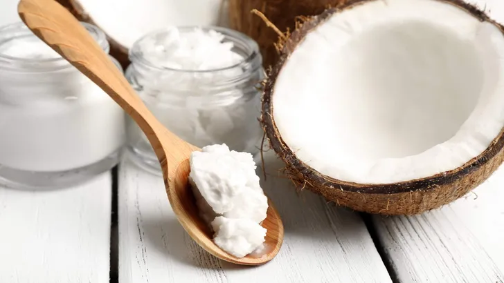 Coconut with jars of coconut oil and cosmetic cream