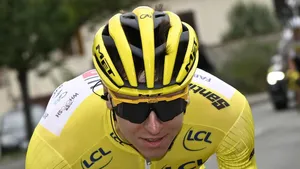 Tadej Pogacar in de gele trui, in close-up voorovergebogen tijdens een Tour-etappe, met helm en donkere bril, gefocust in volle inspanning.