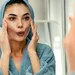 Een vrouw die face yoga aan het doen is in de spiegel