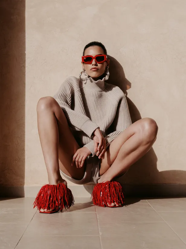 Wollen trui en short: Max Mara | Sandalen en oorbellen: Givenchy by Sarah Burton | Bril: Valentino
