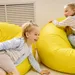 Twee kinderen op een gele zitzak in de kinderhoek