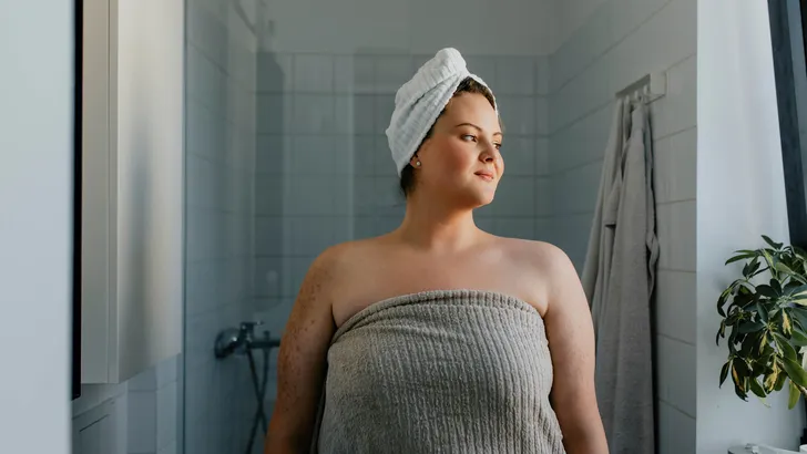 Portrait of a Happy  plus size Woman Standing in the Bathroom after a Relaxing Shower