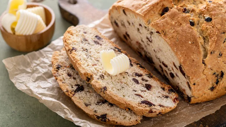 Soda bread in a cast iron pan with cranberries and pecans